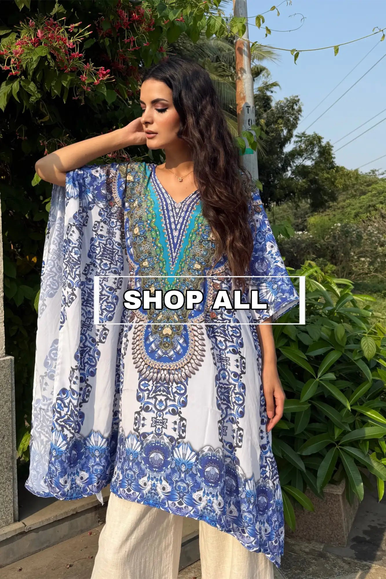 Blue and white patterned kaftan dress with bell sleeves.